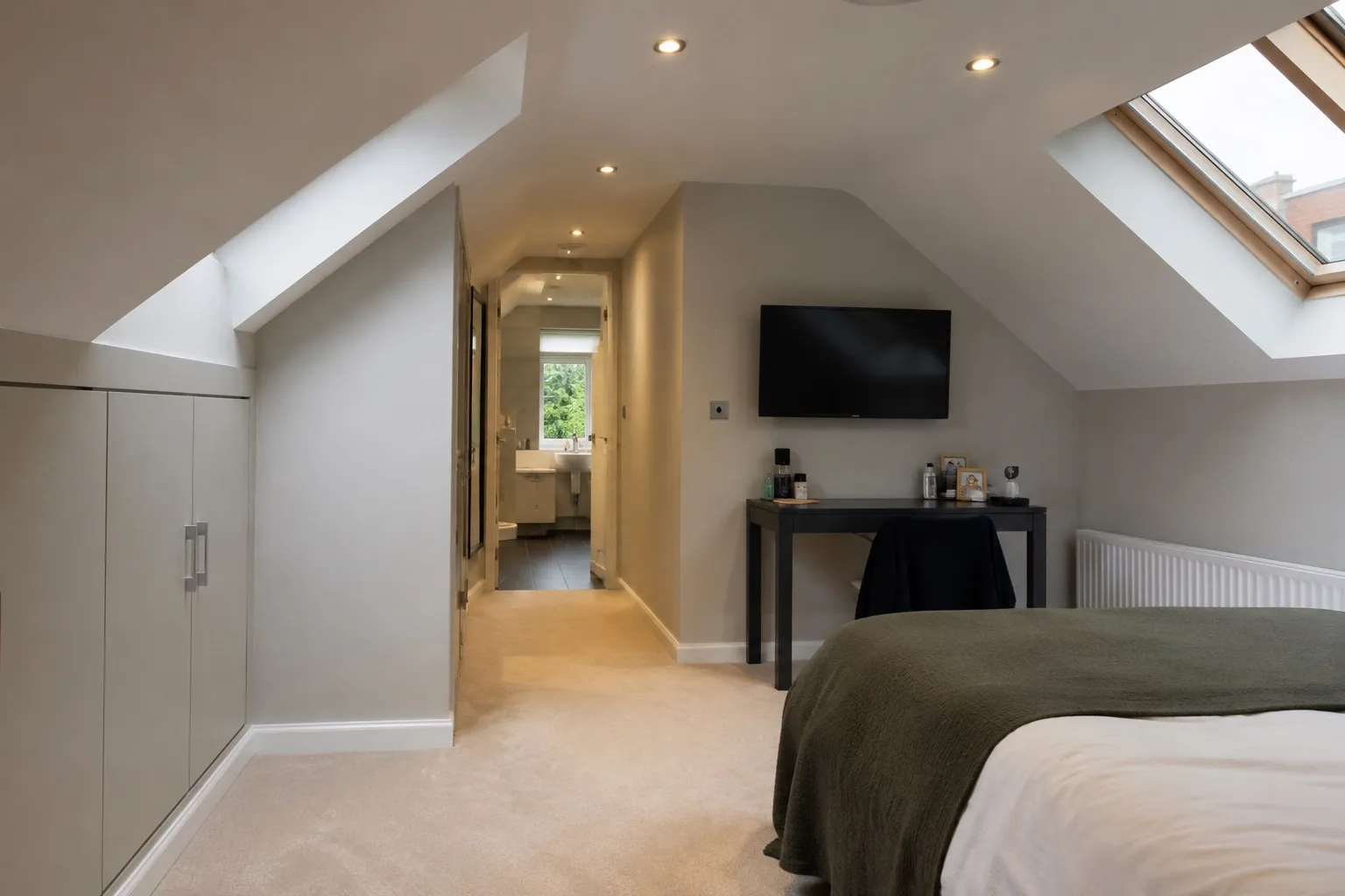 Modern loft bedroom conversion with pitched ceiling and skylights